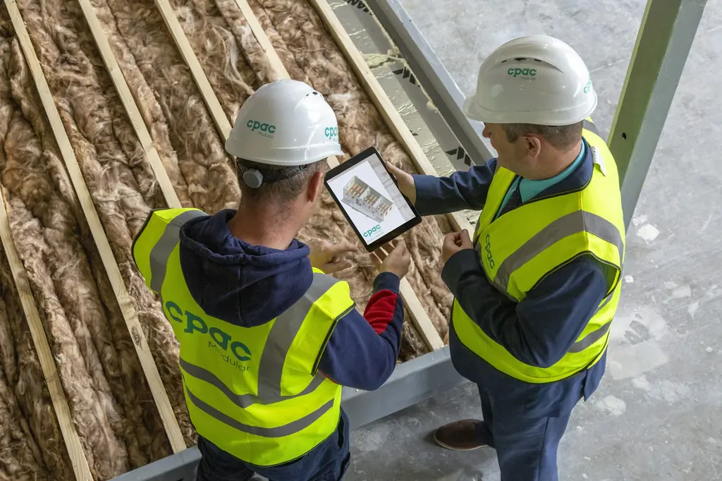 Two site engineers reviewing an inspection checklist on a tablet